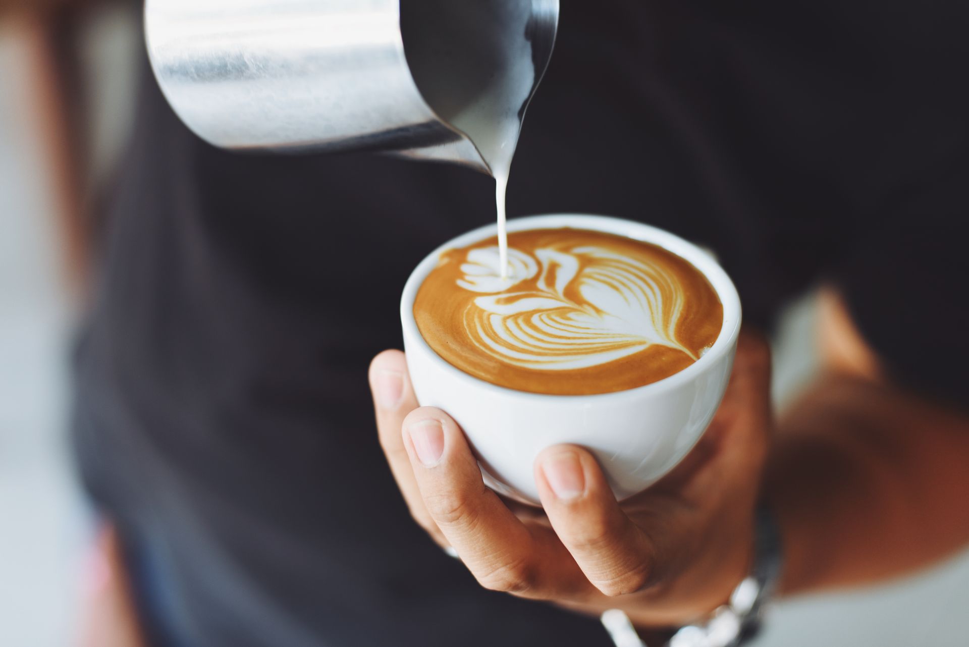 A barista's hands finishing a pour