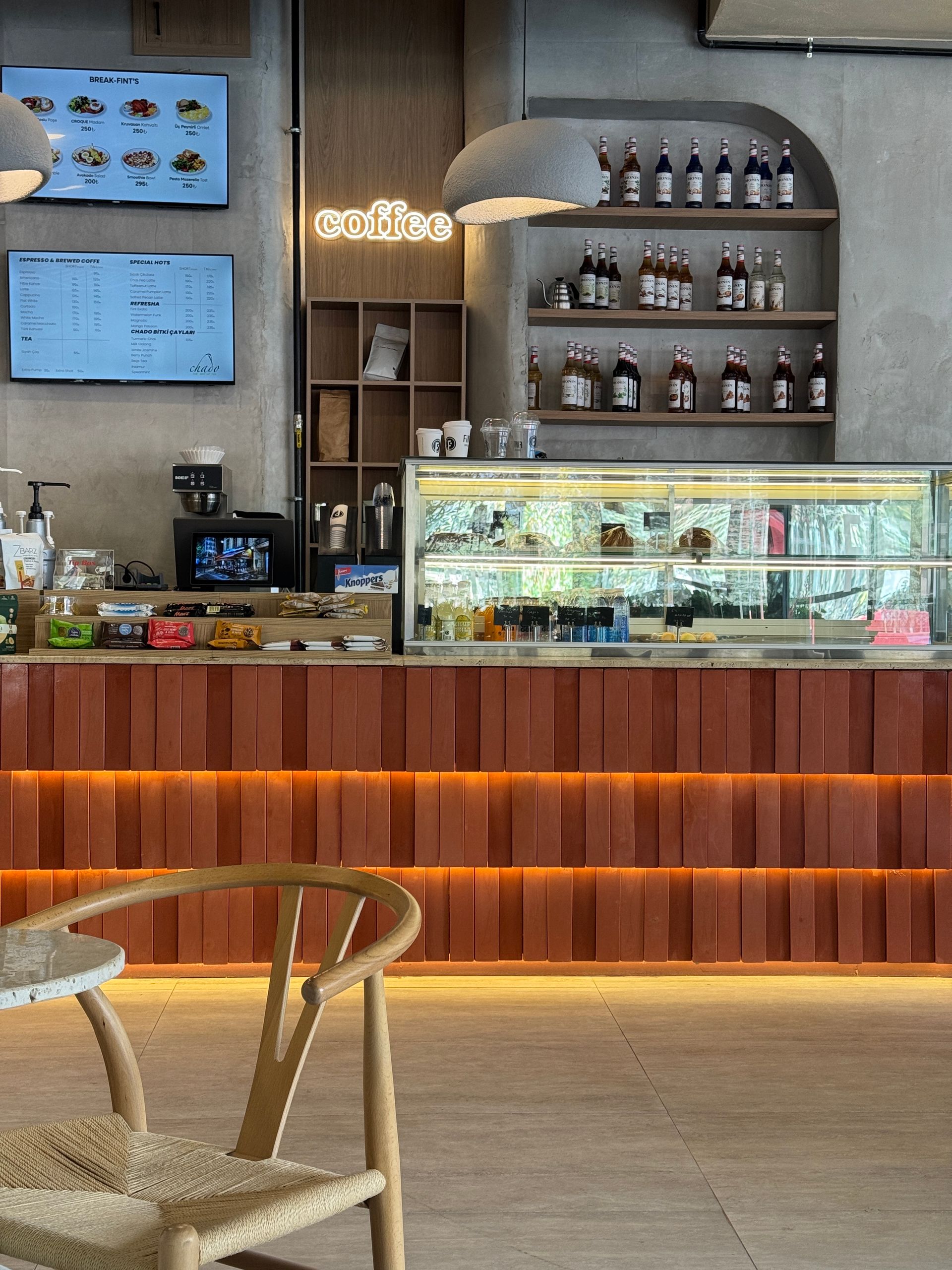 The sheltered side of the cafe, warm timber and soft shade